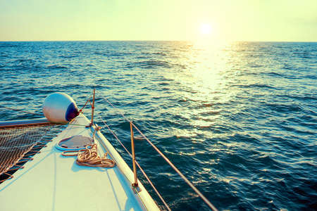 The yacht at sunset. Sailing boat in the sea during sunset. Yachting as a luxury sport and great...