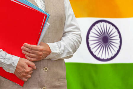 Woman holding red folder on India flag background. Education and jurisprudence concept in India