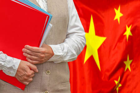Woman holding red folder on China flag background. Education and jurisprudence concept in Chinaの写真素材