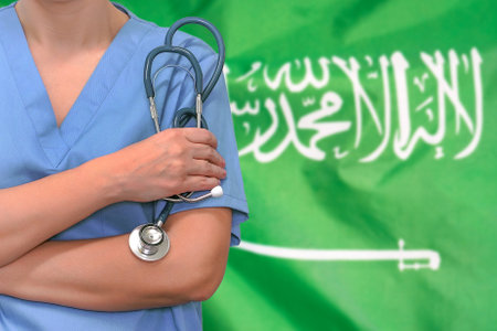 Female surgeon or doctor with stethoscope in hand on the background of the Saudi Arabia flag. Surgery concept in Saudi Arabiaの写真素材