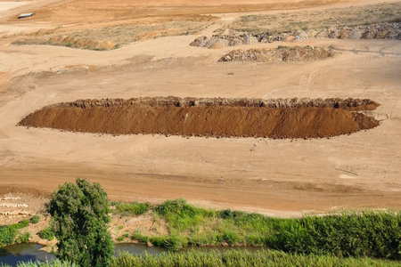 A large pit dug in the field. Large pit. Deep sand pit dug for trash in the field. House construction conceptの写真素材