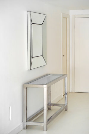Stainless steel table and abstract mirror in hall. Entrance hall of contemporary family homeの写真素材
