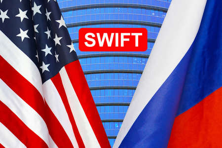 Flag of USA and Russia flag and text of SWIFT. Society for Worldwide Interbank Financial Telecommunications, online payment and financial regulation sanctions conceptの写真素材