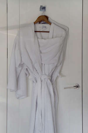 Two white coats hanging on the doorの写真素材