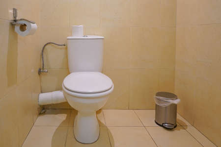 Public toilet in the airport or restaurant, cafe. Closeup of toilet bowl and roll on toilet paper holder in hotelの写真素材