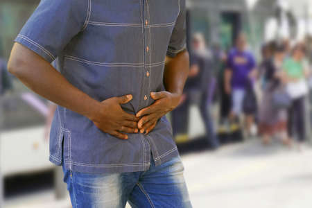 African man having painful stomachache outdoors. Chronic gastritisの写真素材