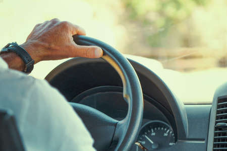 Concept of taxi driver steering wheel and driving passenger taxi. Hands of driver in a modern bus by...