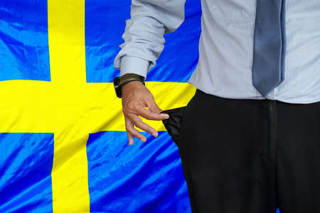 Close-up of hand of man in suit turning pocket of his trousers inside out and showing it empty on...