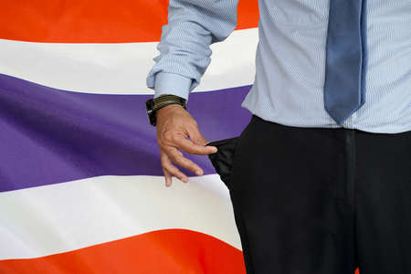 Hand of man in suit turning pocket of his trousers inside out and showing it empty on the background...