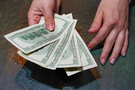 Woman hand with dollars. Businesswoman hands hold and counting dollars banknotes. Concept of corruption and briberyの写真素材