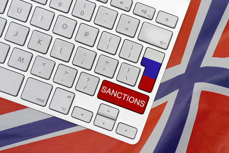 White computer keyboard with button of flag Russia and red button with word of sanctions on Norway flag background. Financial and economic regulation sanctions Norway against Russiaの写真素材