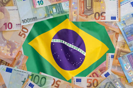 Mockup of Euro banknotes on flag Brazil background. Different Euro banknotes frame. Business, finance, investment, saving and corruption concept in Brazilの写真素材