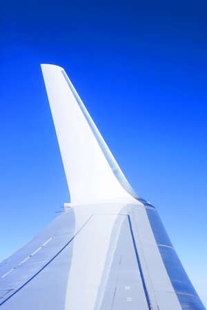 Wing of the plane in the blue skyの写真素材