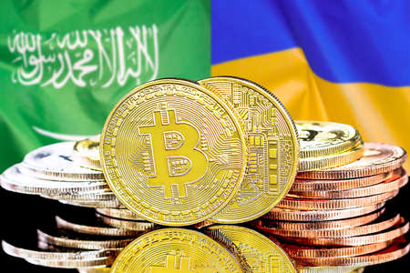 Bitcoins on the background of flag Saudi Arabia and Ukraine. Concept for investors in cryptocurrency and Blockchain technology in Saudi Arabia and Ukraineの写真素材