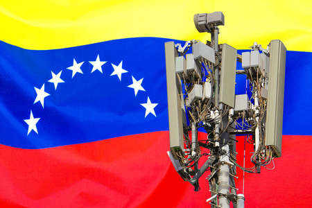 Telecommunications tower with a 5G cellular network antenna agains flag of Venezuela. Telecommunication tower of 5G cellular communication. 5G technology usage on telecommunications towers in Venezuelaの写真素材