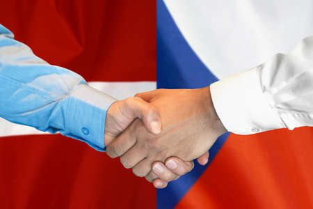 Business handshake on background of two flags. Men handshake on background of Czech Republic and Latvia flag. Support conceptの写真素材
