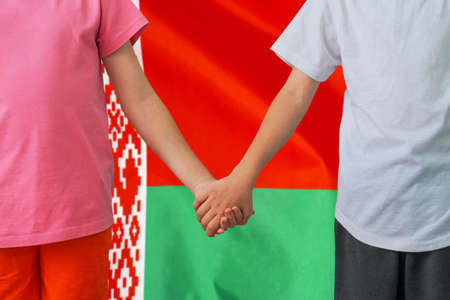 Two children joined hands on flag Belarus background. Boy and girl joined hands on background flag...