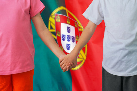 Two children joined hands on flag Portugal background. Boy and girl joined hands on background flag of Portugal. Concept of family and parenting in Portugalの写真素材