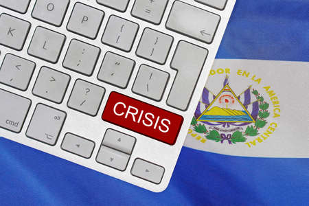 White computer keyboard with red button with word of crisis on El Salvador flag background. Global economic, political and financial crisis. Economic crisis and economic recession in El Salvadorの写真素材