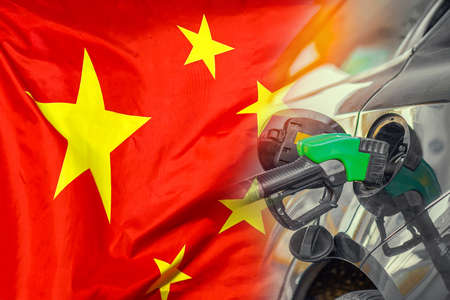 Car with a fuel injector on China flag background. Record fuel prices for population. Gasoline price increase during energy and fuel world crisis in Chinaの写真素材