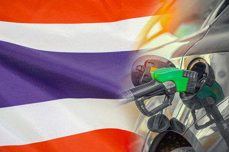 Car with a fuel injector on Thailand flag background. Record fuel prices for population. Gasoline price increase during energy and fuel world crisis in Thailandの写真素材