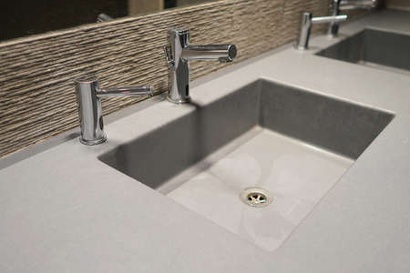 Interior of bathroom with washbasin and faucet. Public bathroom in the airport or restaurant, cafe. Bathroom interior sink with modern design in luxury hotelの写真素材