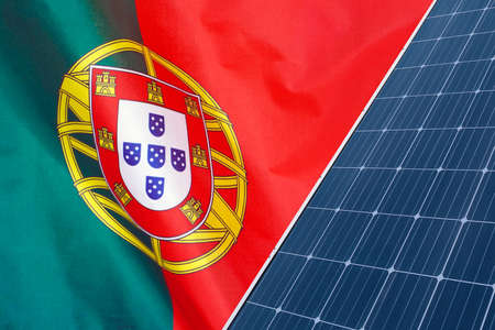Solar panels against flag Portugal background. Solar battery generates a pure electricity. Concept of sustainable resources and renewable energy in Portugalの写真素材