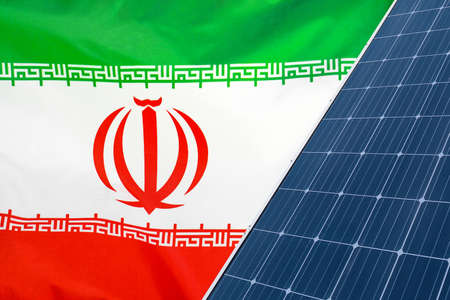 Solar panels against flag Iran background. Solar battery generates a pure electricity. Concept of sustainable resources and renewable energy in Iranの写真素材