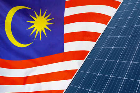 Solar panels against flag Malaysia background. Solar battery generates a pure electricity. Concept of sustainable resources and renewable energy in Malaysiaの写真素材