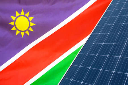 Solar panels against flag Namibia background. Solar battery generates a pure electricity. Concept of sustainable resources and renewable energy in Namibiaの写真素材