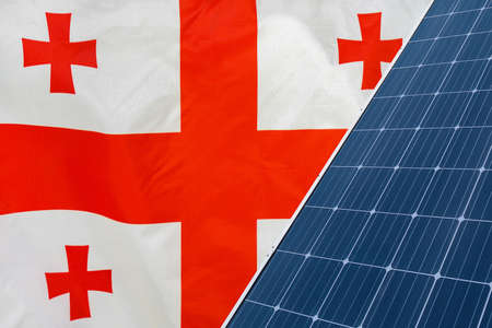 Solar panels against flag Georgia background. Solar battery generates a pure electricity. Concept of sustainable resources and renewable energy in Georgiaの写真素材