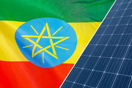 Solar panels against flag Ethiopia background. Solar battery generates a pure electricity. Concept of sustainable resources and renewable energy in Ethiopiaの写真素材