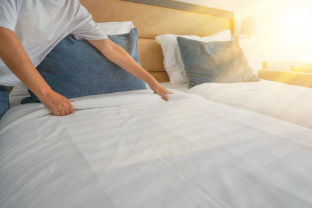 Hand of young woman maid making bed in hotel room. Housekeeper Making Bedの写真素材