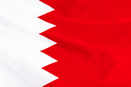 Fabric texture flag of Bahrain. Flag of Bahrain waving in the wind. Bahrain flag is depicted on a sports cloth fabric with many folds. sport team bannerの写真素材