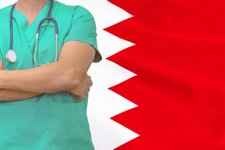 Male surgeon or doctor with stethoscope on flag of Bahrain background. Health care and medical concept. Surgery concept in Bahrainの写真素材