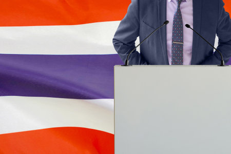 Tribune with microphone and man in suit on Thailand flag background. Businessman and tribune on Thailand flag background. Politician at the podium with microphones background Thailand flag. Conferenceの写真素材