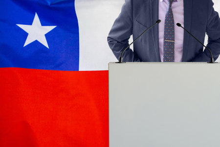 Tribune with microphone and man in suit on Chile flag background. Businessman and tribune on Chile flag background. Politician at the podium with microphones background Chile flag. business conferenceの写真素材