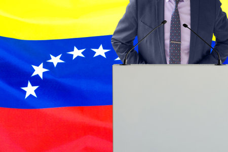 Tribune with microphone and man in suit on Venezuela flag background. Businessman and tribune on Venezuela flag background. Politician at the podium with microphones background Venezuela flagの写真素材