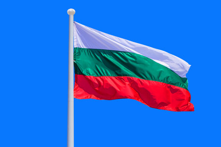 Bulgaria flag waving against clean blue sky, close up. Bulgaria flag in the blue sky. Flag Bulgaria on blue sky backgroundの写真素材