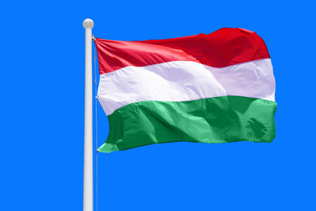 Hungary flag waving against clean blue sky, close up. Hungary flag in the blue sky. Flag Hungary on blue sky backgroundの写真素材