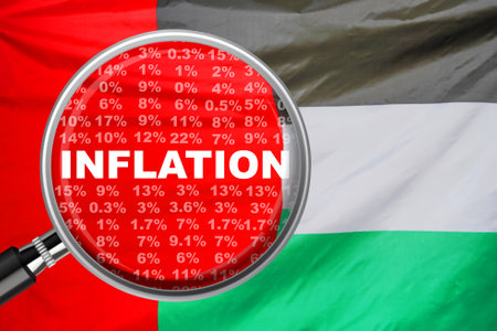 Magnifying glass focused on the word inflation on flag of United Arab Emirates background. inflation income crisis. Inflation, tax, cash flow and another financial concept in UAEの写真素材