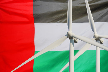 Two Wind Turbines for alternative energy on flag of United Arab Emirates background. energy development. Eco power and wind stations for renewable electric energy production in United Arab Emiratesの写真素材