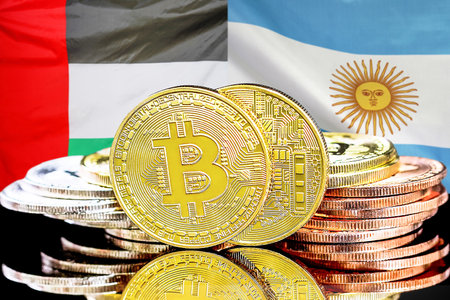 Bitcoins on flag of United Arab Emirates and Argentina flag background. Concept for investors in cryptocurrency and Blockchain technology in UAE and Argentinaの写真素材