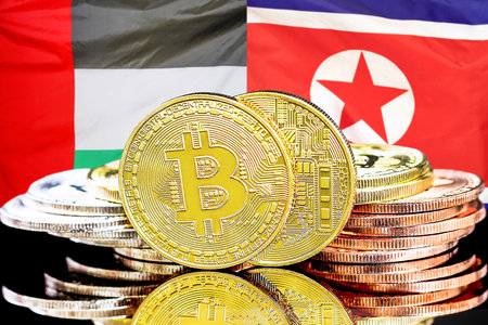 Bitcoins on flag of United Arab Emirates and North Korea flag background. Concept for investors in cryptocurrency and Blockchain technology in UAE and North Koreaの写真素材