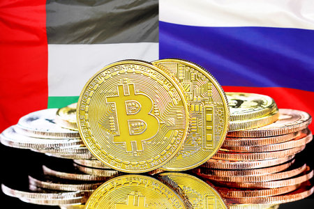 Bitcoins on flag of United Arab Emirates and Russia flag background. Concept for investors in cryptocurrency and Blockchain technology in UAE and Russiaの写真素材