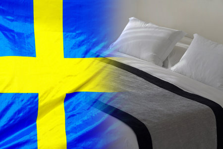 Hotel bed on the background of the Sweden flag. Tourism and hotel business in Swedenの写真素材