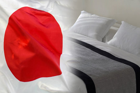 Hotel bed on the background of the Japan flag. Tourism and hotel business in Japanの写真素材