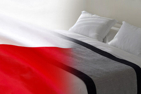 Hotel bed on the background of the Poland flag. Tourism and hotel business in Polandの写真素材
