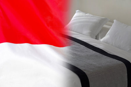 Hotel bed on the background of the Indonesia flag. Tourism and hotel business in the Indonesiaの写真素材