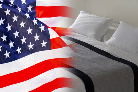 Hotel bed on the background of the US flag. Tourism and hotel business in the USAの写真素材